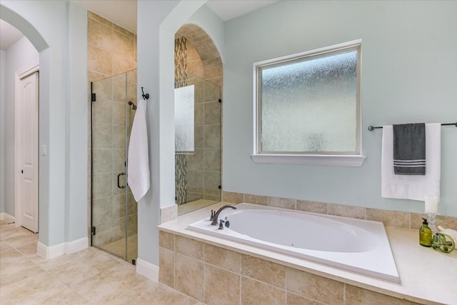 bathroom with a stall shower and a garden tub