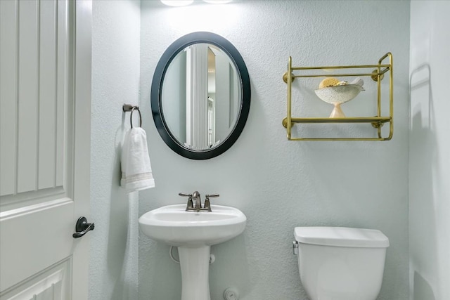 half bathroom featuring a sink and toilet