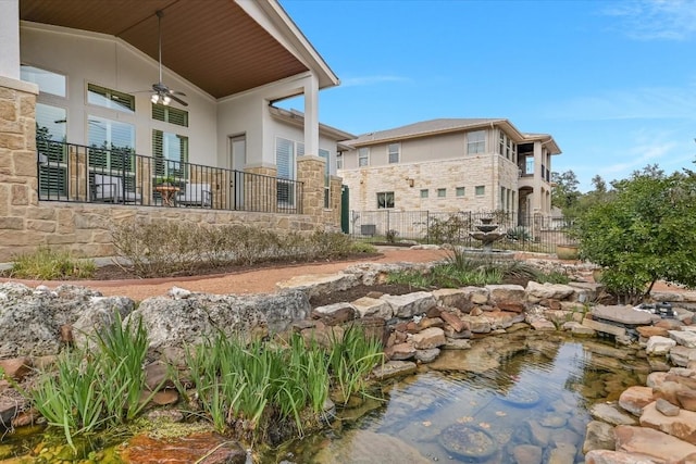 exterior space with ceiling fan and fence