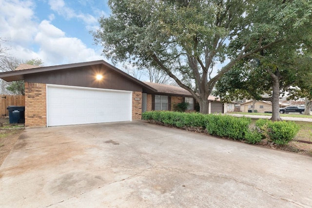 view of front of house with driveway, a garage, and brick siding