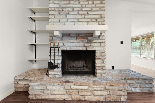 details featuring a fireplace, baseboards, and wood finished floors