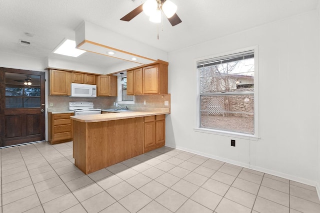 kitchen featuring light countertops, white appliances, a peninsula, and brown cabinets