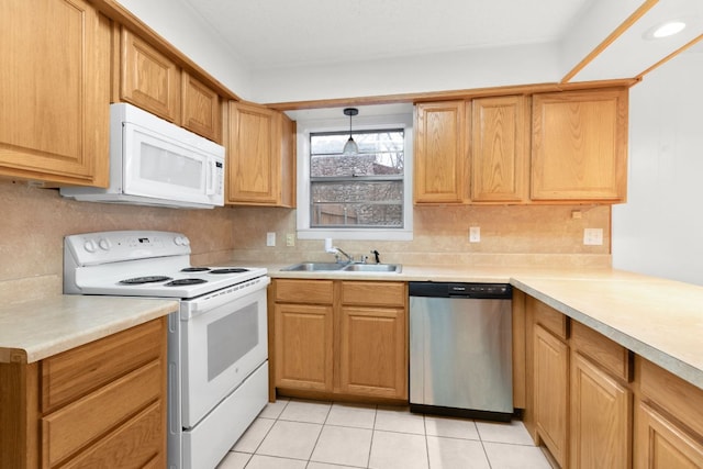 kitchen with light tile patterned floors, white appliances, a sink, light countertops, and hanging light fixtures