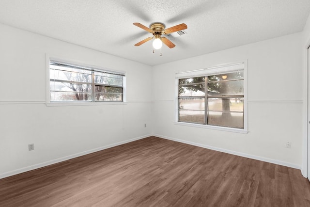 unfurnished room featuring a textured ceiling, wood finished floors, a ceiling fan, and baseboards