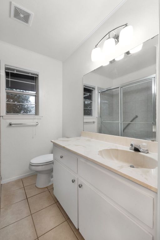 full bathroom with visible vents, toilet, a stall shower, vanity, and tile patterned flooring