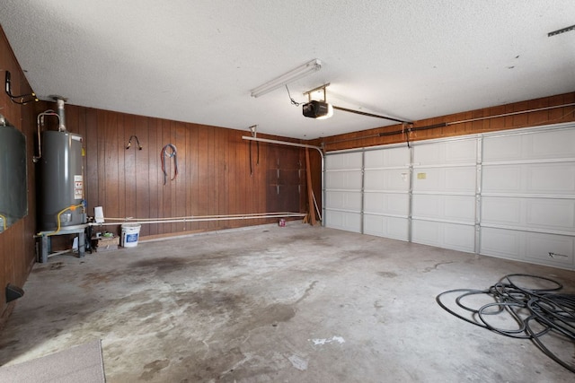 garage featuring wooden walls, water heater, and a garage door opener