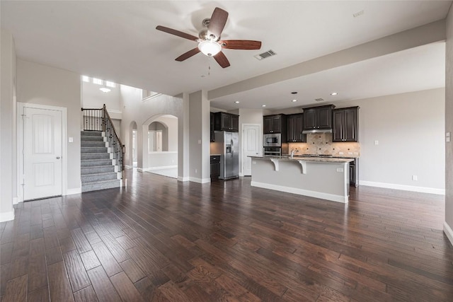 201 Seminole Canyon Dr, Georgetown, TX 78628 - unfurnished living room featuring ceiling fan, stairs, arched walkways, dark wood-type flooring, and recessed lighting