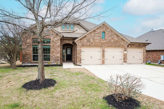 traditional-style home with brick siding, a shingled roof, a front yard, a garage, and driveway