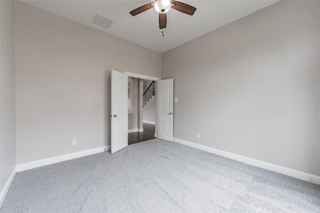 unfurnished bedroom featuring carpet floors, a ceiling fan, visible vents, and baseboards