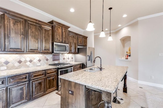 kitchen with an island with sink, a breakfast bar, stainless steel appliances, dark brown cabinets, and a sink