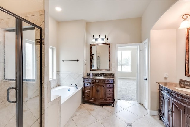 1312 Mustang Brook Ln, Leander, TX 78641 - full bathroom featuring two vanities, a garden tub, a stall shower, and tile patterned floors
