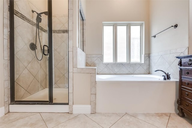 bathroom with a stall shower, a bath, and tile patterned floors