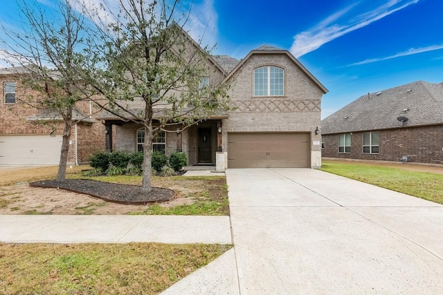 traditional-style home featuring a garage, a front yard, brick siding, and driveway