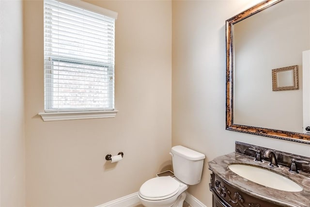 bathroom with vanity, toilet, and baseboards