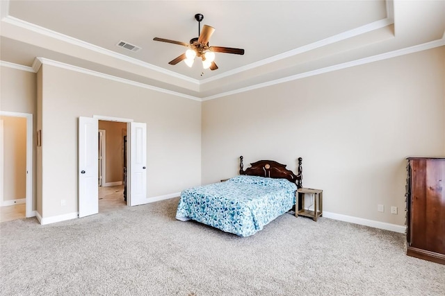 carpeted bedroom featuring a tray ceiling, visible vents, and baseboards