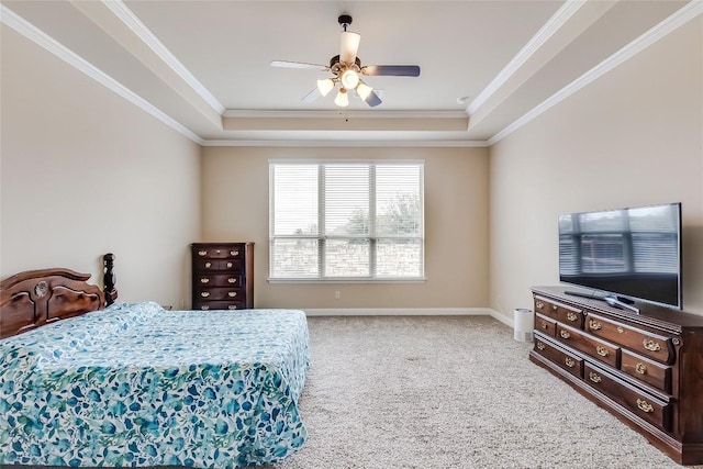 bedroom with ceiling fan, carpet flooring, baseboards, a raised ceiling, and crown molding