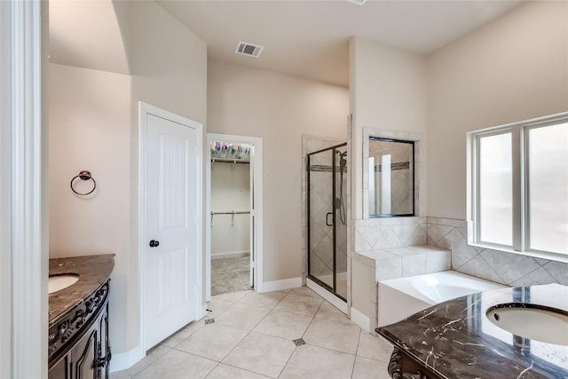 1312 Mustang Brook Ln, Leander, TX 78641 - full bathroom featuring a shower stall, vanity, a spacious closet, a garden tub, and tile patterned floors