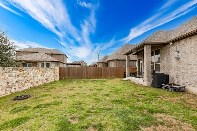 view of yard with a wall unit AC and a fenced backyard