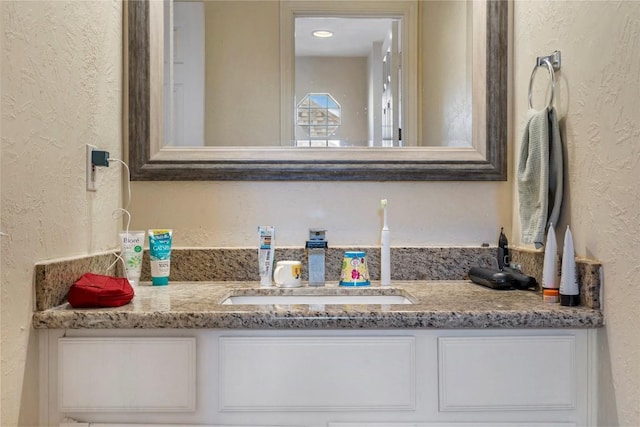 bathroom with vanity and a textured wall