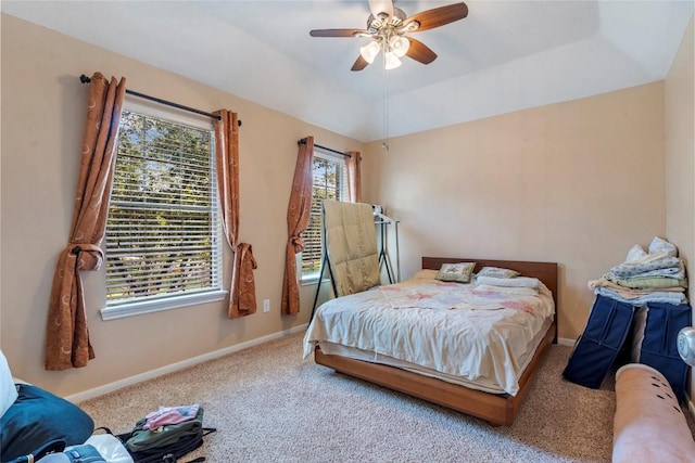 bedroom with baseboards, a ceiling fan, lofted ceiling, a tray ceiling, and carpet floors