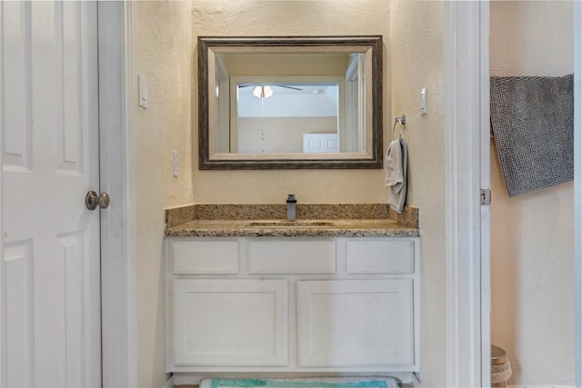 bathroom with a textured wall and vanity