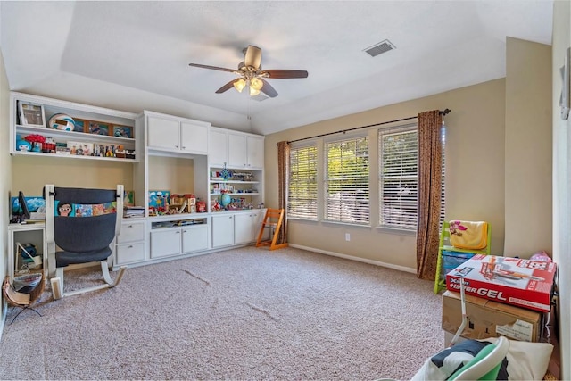 interior space featuring carpet floors, visible vents, vaulted ceiling, ceiling fan, and baseboards