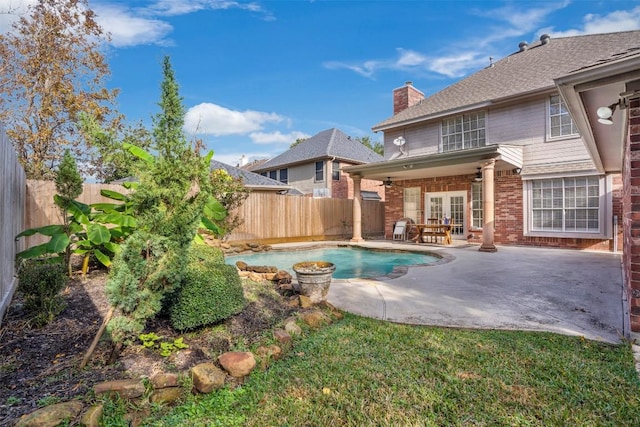 view of swimming pool featuring a patio area, a fenced backyard, a fenced in pool, and french doors