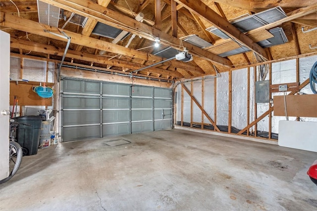 garage with a garage door opener and electric panel