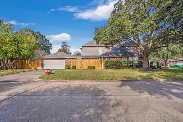 view of front of house featuring a garage, brick siding, fence, driveway, and a front yard