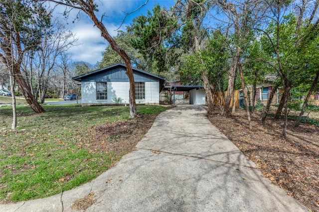 view of front of house with driveway, a front lawn, a carport, and brick siding