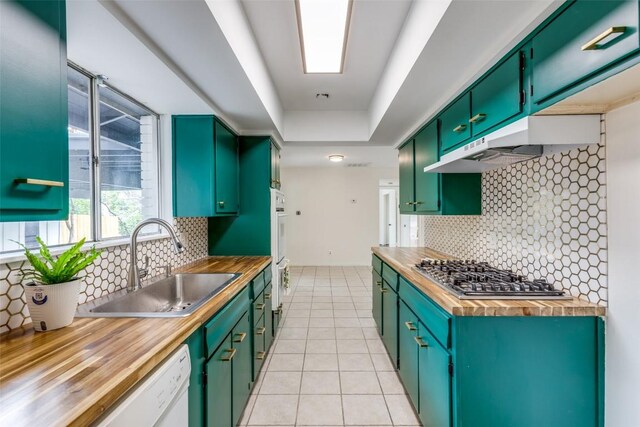 400 Cherry Hill Dr, Austin, TX 78704 - kitchen featuring stainless steel gas stovetop, butcher block countertops, under cabinet range hood, light tile patterned floors, and backsplash