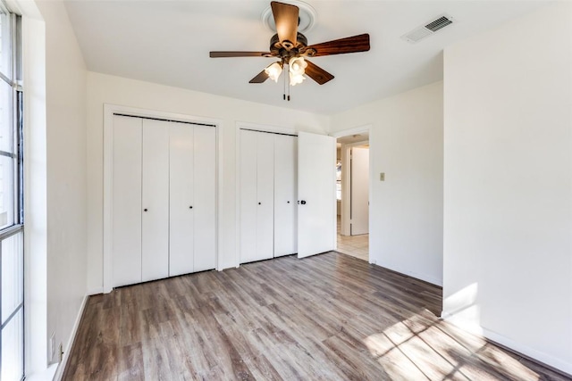 400 Cherry Hill Dr, Austin, TX 78704 - unfurnished bedroom with two closets, baseboards, visible vents, and wood finished floors