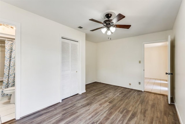 400 Cherry Hill Dr, Austin, TX 78704 - unfurnished bedroom with a closet, baseboards, visible vents, connected bathroom, and wood finished floors