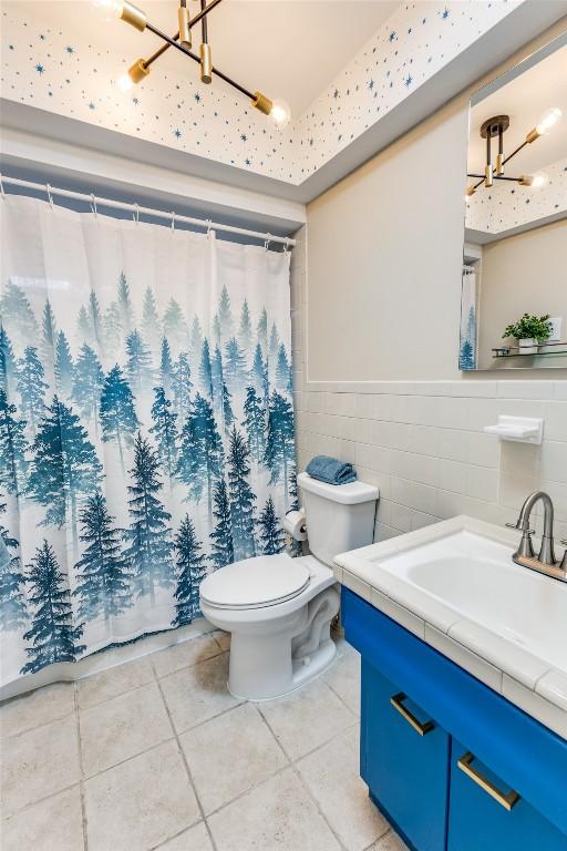 400 Cherry Hill Dr, Austin, TX 78704 - full bath featuring a shower with curtain, toilet, tile patterned floors, vanity, and a wainscoted wall