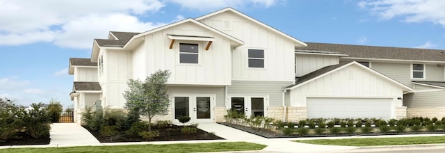 view of front of house with a garage, board and batten siding, and roof with shingles