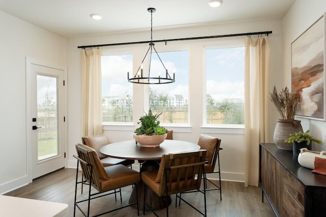 dining space featuring a chandelier, recessed lighting, baseboards, and wood finished floors