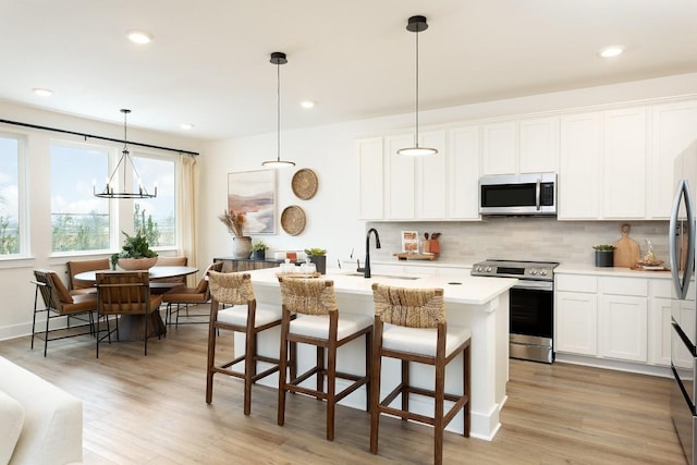 kitchen featuring a sink, white cabinets, stainless steel appliances, and light countertops