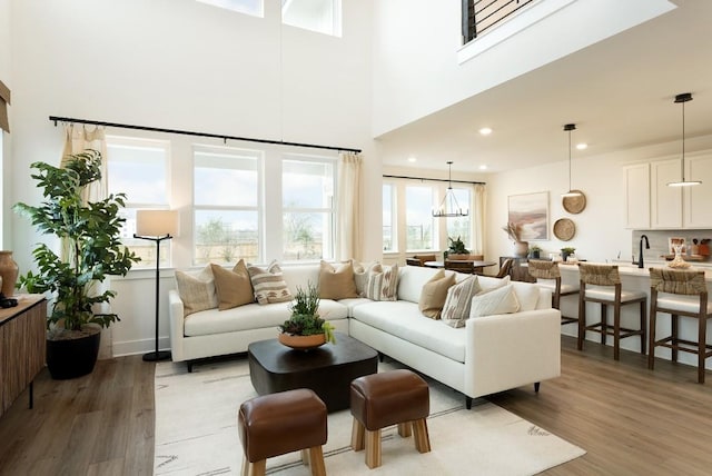 living room featuring a towering ceiling, dark wood-style flooring, and recessed lighting