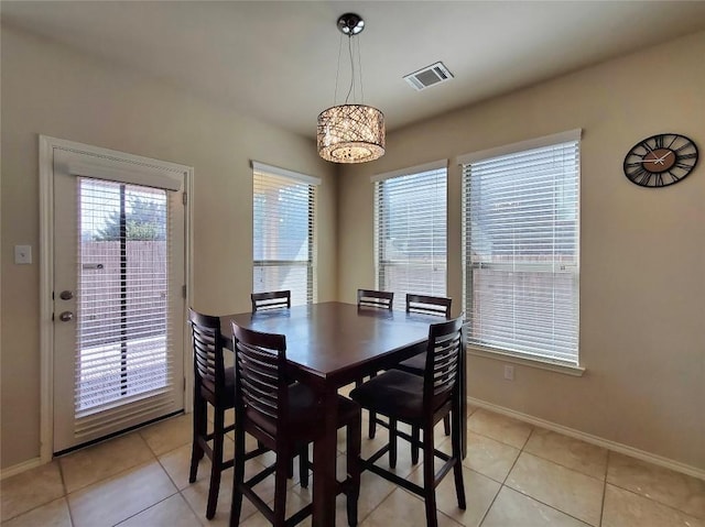 dining space with light tile patterned floors, baseboards, and visible vents