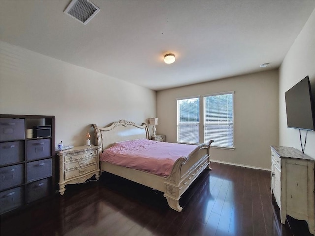 bedroom with baseboards, visible vents, and dark wood-type flooring