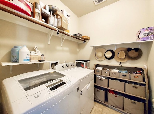 washroom with laundry area, visible vents, and washer and clothes dryer