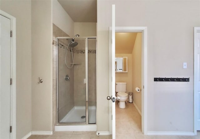 full bathroom with a stall shower, baseboards, tile patterned flooring, and toilet