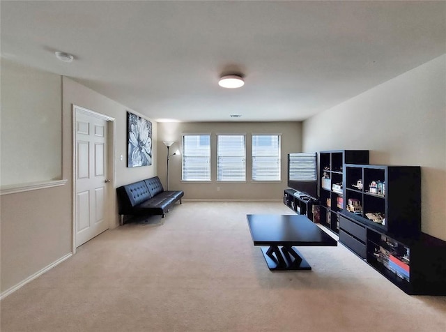 living area featuring baseboards and light colored carpet