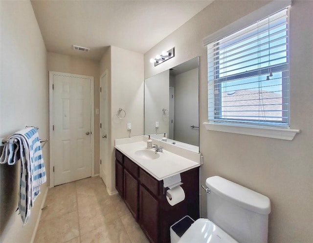 bathroom featuring toilet, vanity, visible vents, and tile patterned floors