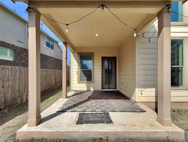 doorway to property with fence and a patio