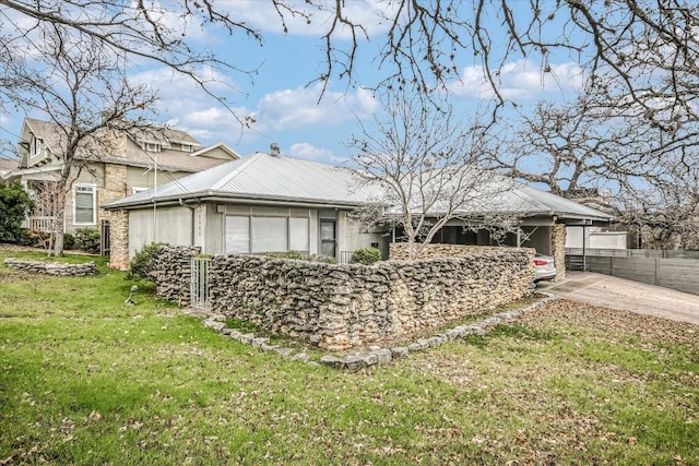 view of front of property featuring driveway, fence, and a front yard