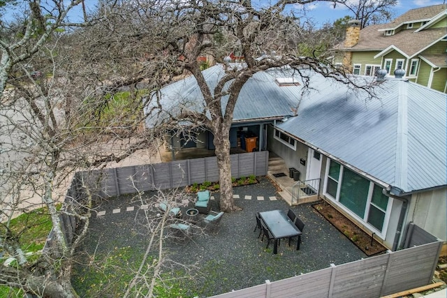 exterior space featuring metal roof and fence