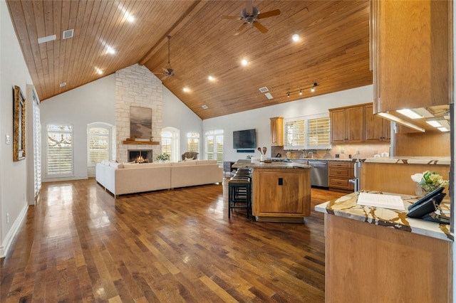 kitchen with a kitchen breakfast bar, open floor plan, a center island, high vaulted ceiling, and stainless steel dishwasher