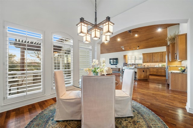 dining room with dark wood-style floors, arched walkways, high vaulted ceiling, recessed lighting, and a chandelier