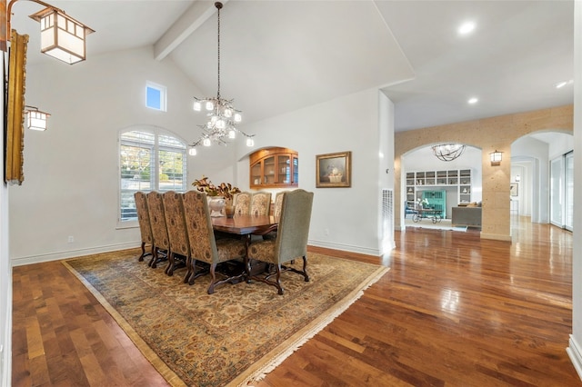 dining room featuring arched walkways, a notable chandelier, wood finished floors, beamed ceiling, and baseboards